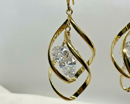 Sculptural gold twist drop earrings laid flat on cream surface – VEESA BY N jewelry