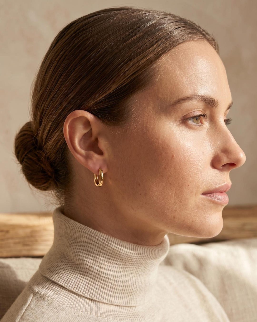 Minimalist oval huggie hoop earrings on model