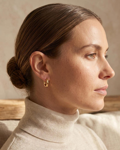Minimalist oval huggie hoop earrings on model