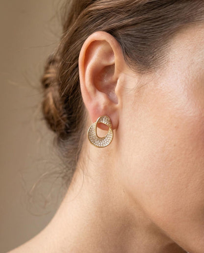 Crystal pavé ribbon stud earrings lifestyle shot — gold finish, worn on ear