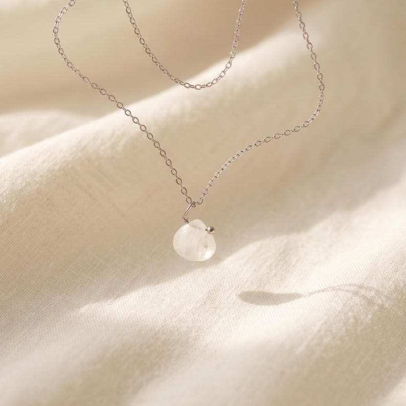 Dainty moonstone pendant layering necklace on neck