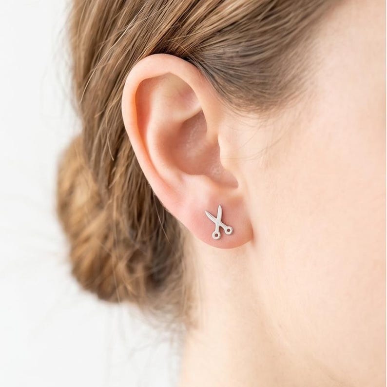 Scissors stud earrings worn by hairstylist