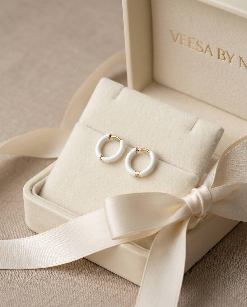 Dainty gold huggie hoops with white enamel