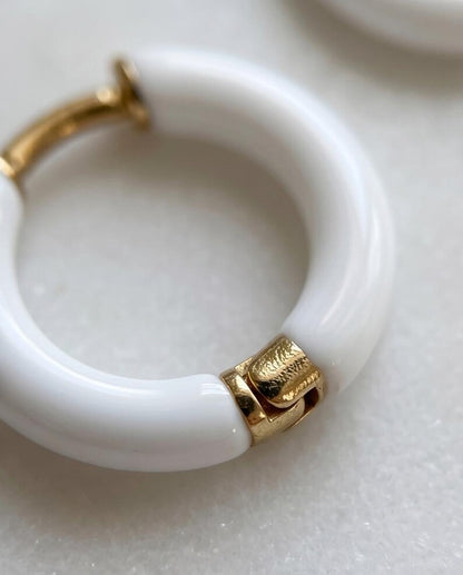 White enamel gold huggie hoops on model