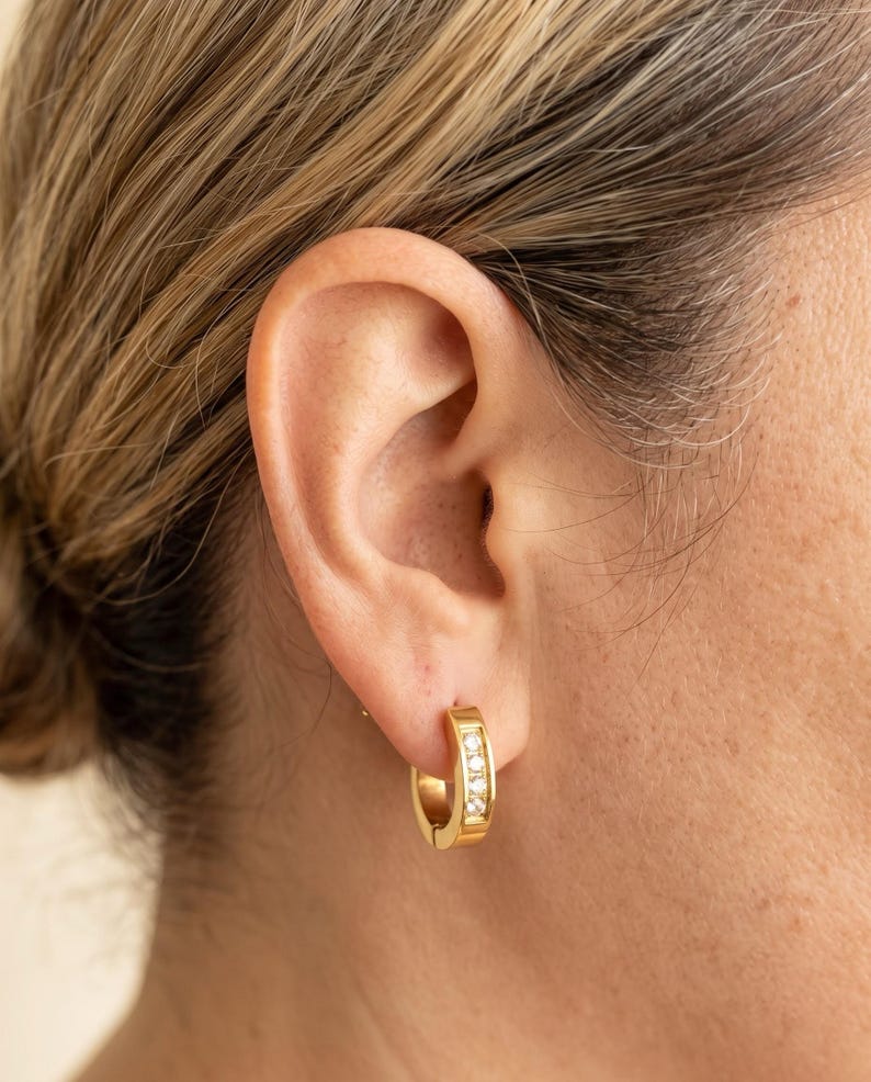 Gold horseshoe huggie hoop earrings worn
