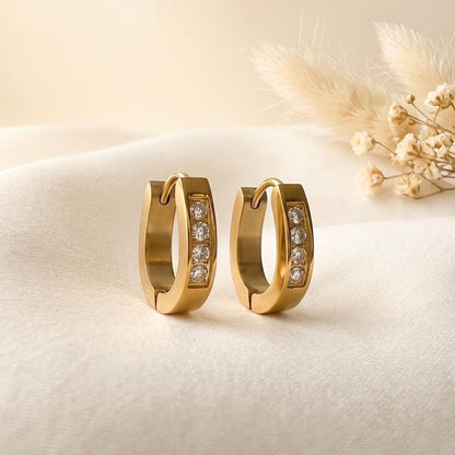 Gold horseshoe huggie hoop earrings close-up