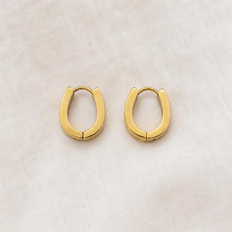 Gold horseshoe huggie hoop earrings close view