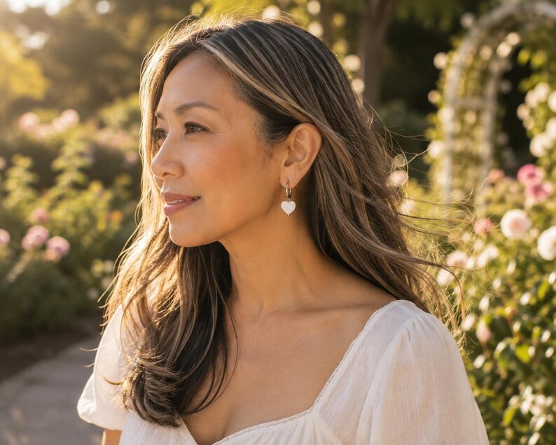 Model wearing Mother of Pearl heart earring outdoors