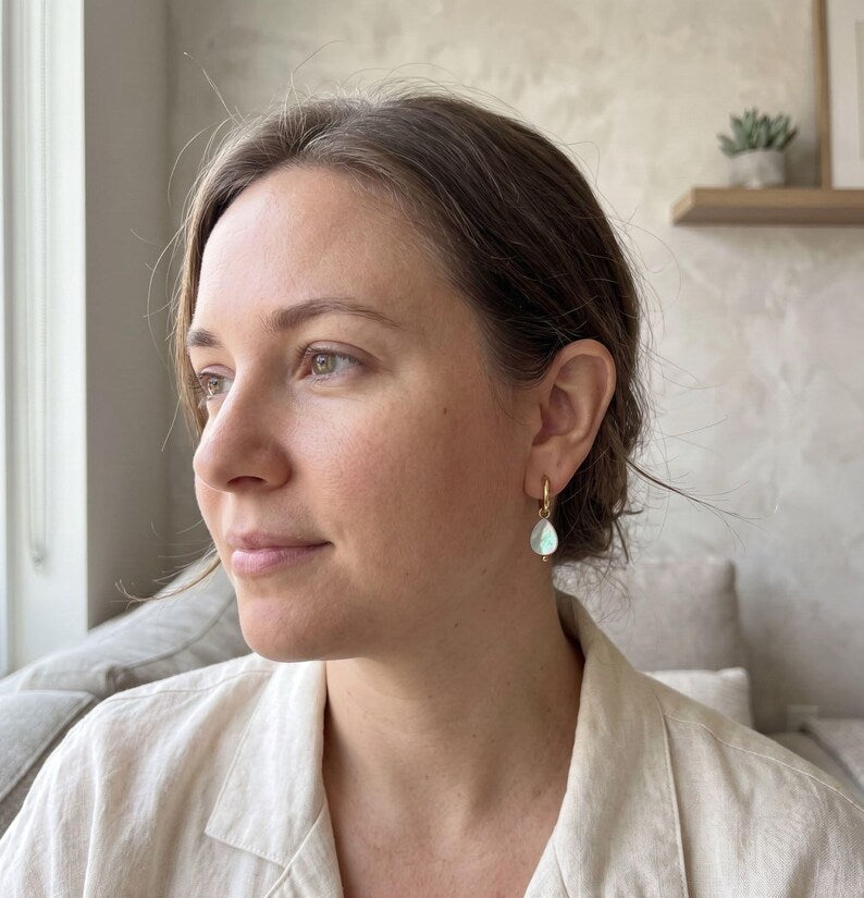 Model wearing teardrop-shaped Mother of Pearl charm earring