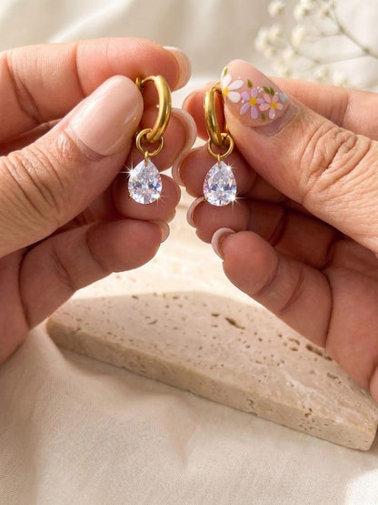 Pair of gold huggie earrings with CZ teardrop charms