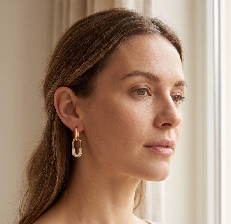 Model wearing gold safety pin huggie hoop earring