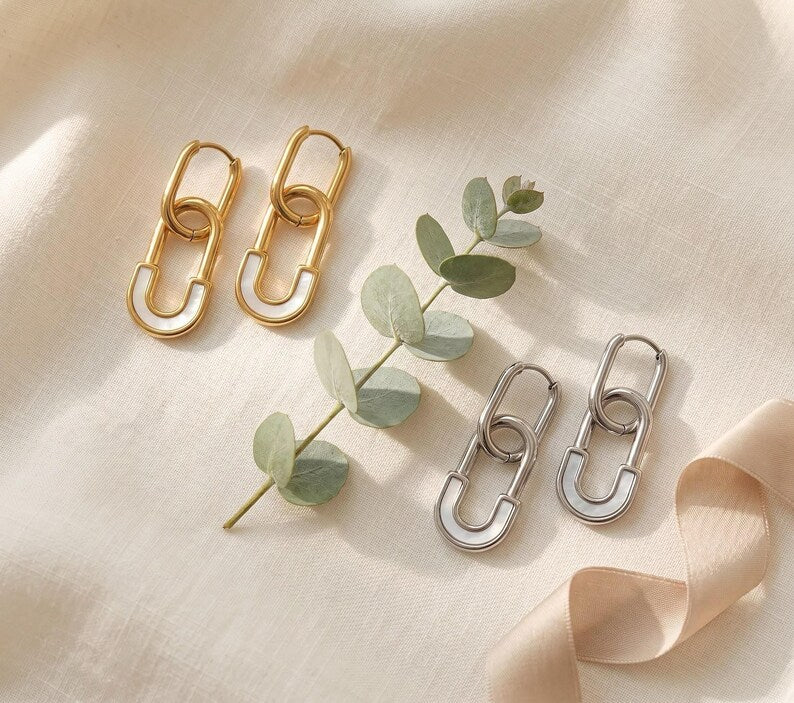 Gold and silver safety pin huggie hoop earrings with eucalyptus