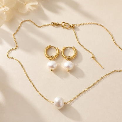 Pearl necklace and matching huggie earrings arranged together