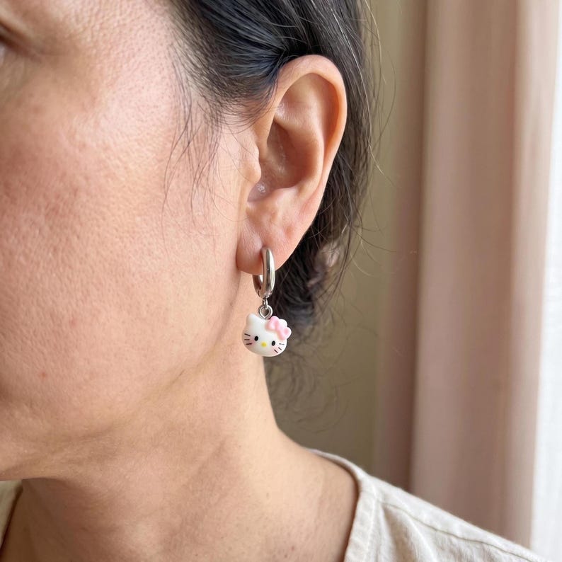 Model wearing kitty charm huggie hoop earring