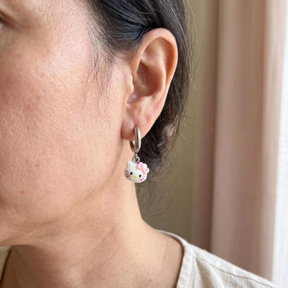 Model wearing kitty charm huggie hoop earring