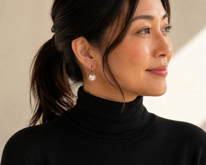 Model in black turtleneck wearing kitty charm earring