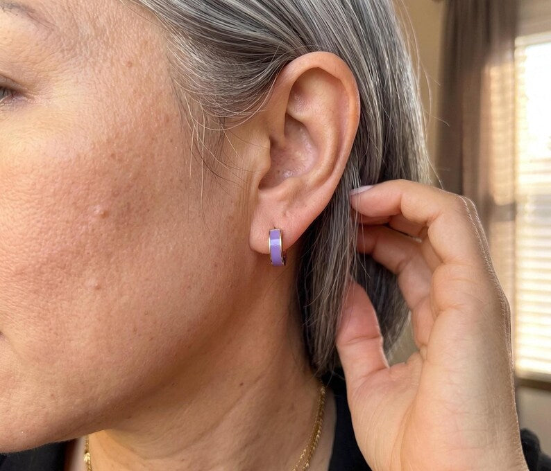 Model wearing purple enamel huggie hoop earring