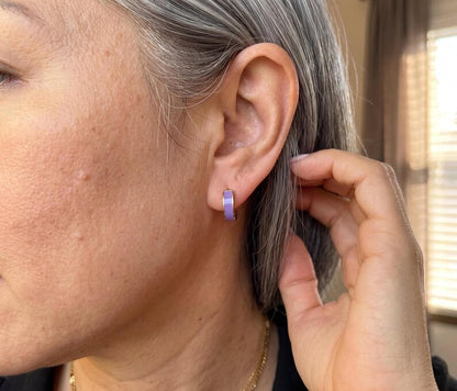 Model wearing purple enamel huggie hoop earring