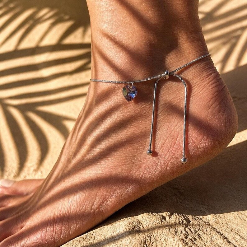 Close up of anklet under palm leaf shadows