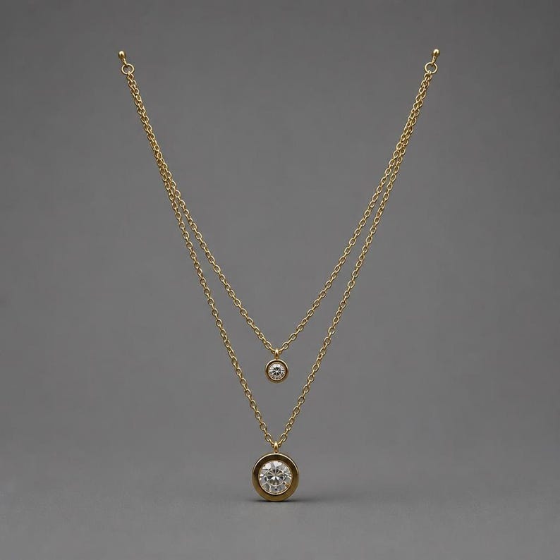 Layered gold CZ necklace on gray background