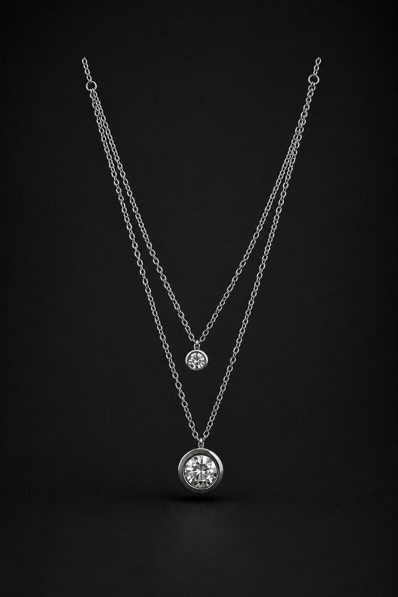 Layered silver CZ necklace on black background