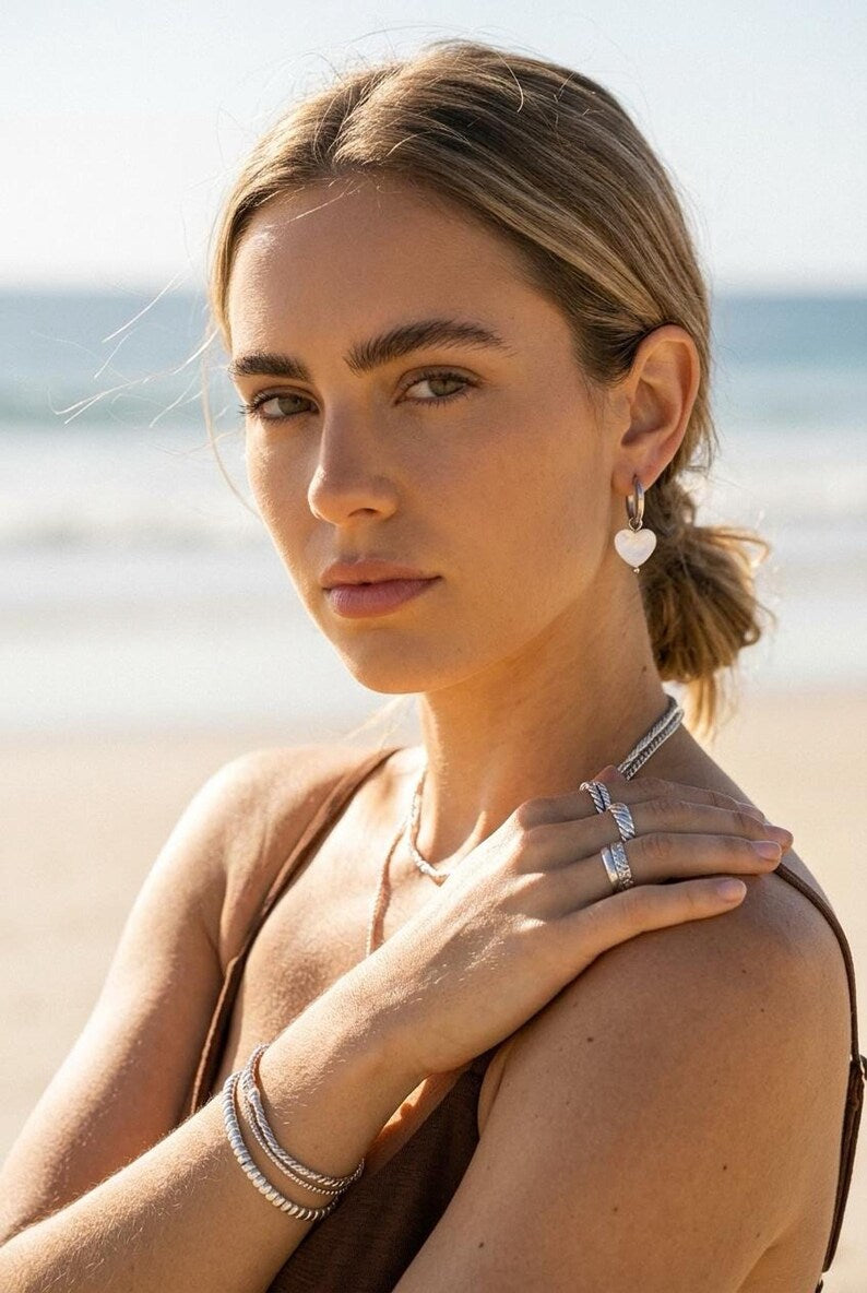 Model wearing Mother of Pearl heart earring at beach