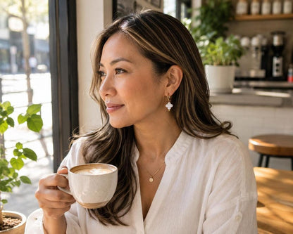 Model wearing Mother of Pearl clover earring with coffee