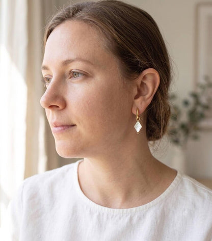 Model wearing diamond-shaped Mother of Pearl charm earring