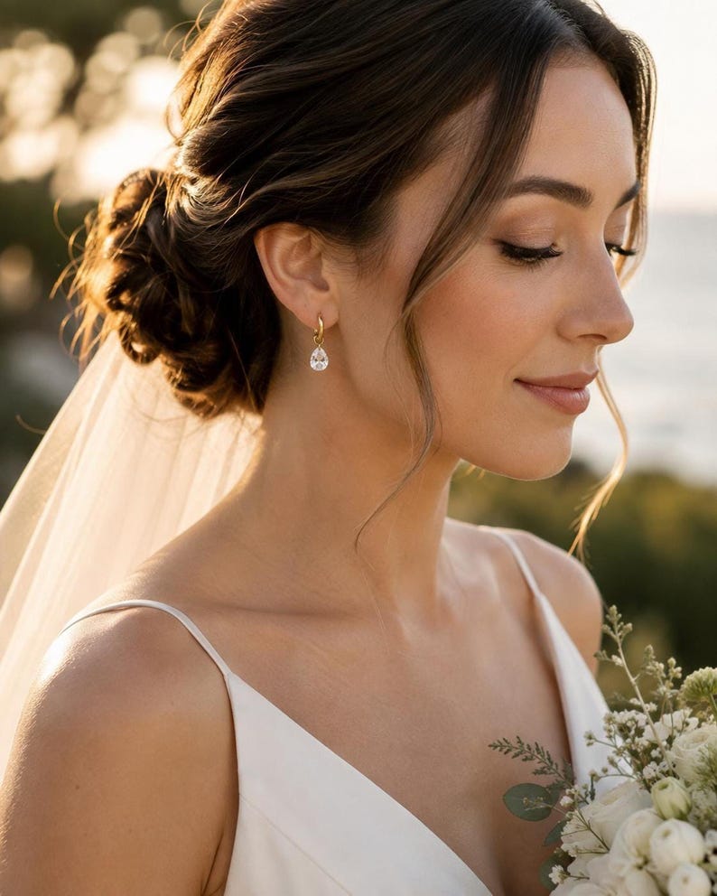 Bride wearing gold huggie earring with CZ teardrop