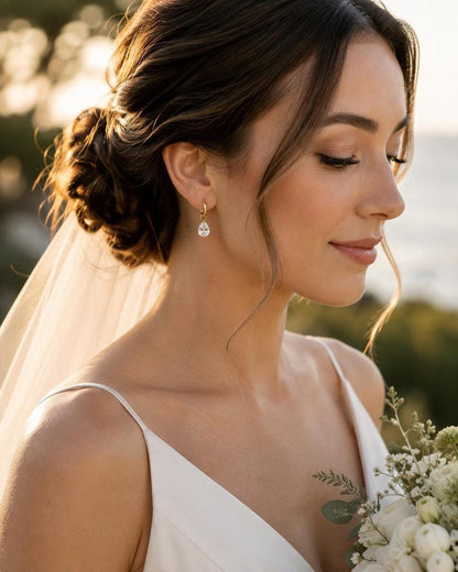 Bride wearing gold huggie earring with CZ teardrop