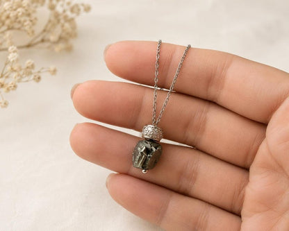 Hand holding raw hematite pendant necklace