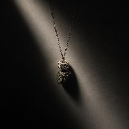 Raw hematite pendant necklace against dark background