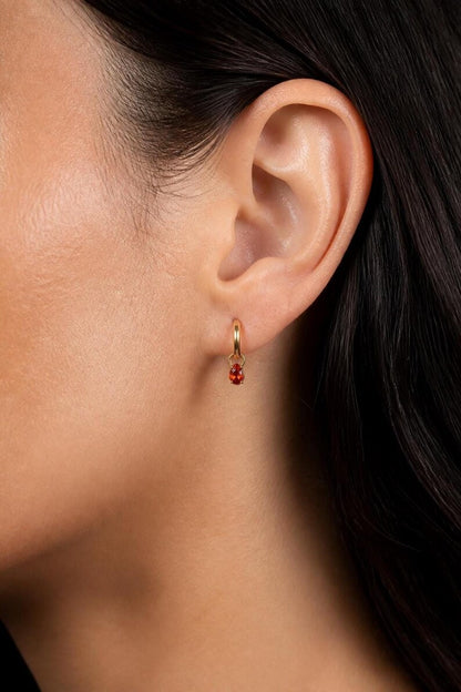 Close up profile of red garnet CZ huggie hoop
