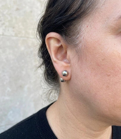 Ball stud earrings styled in an ear stack