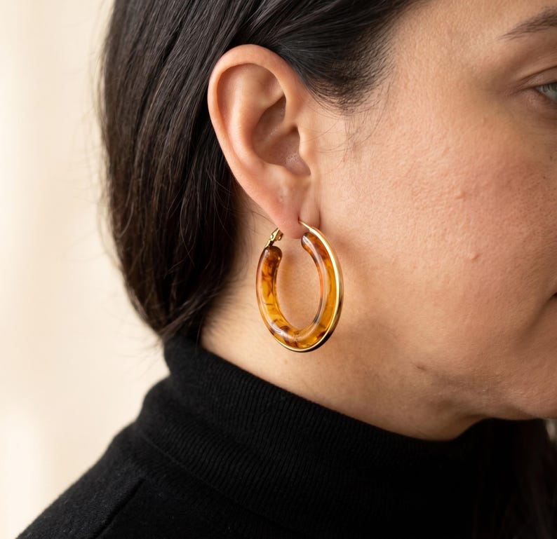Side profile of person wearing amber hoop earring