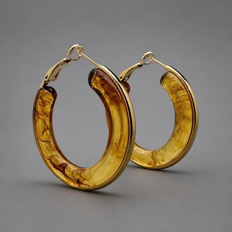 Studio shot of gold-rimmed tortoiseshell resin hoop earrings