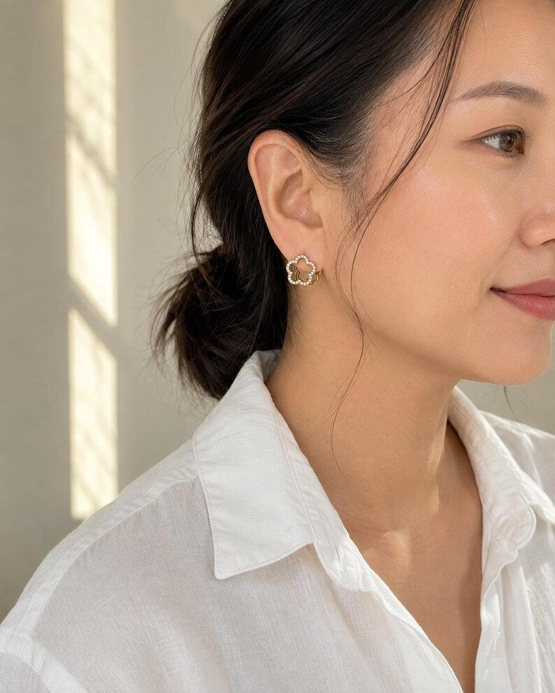 Side view of person wearing gold floral huggie earring