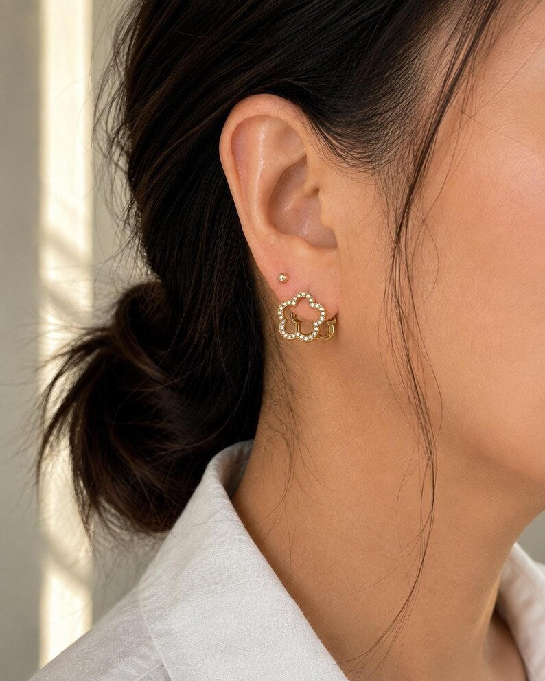 Macro side view of pave stone gold flower hoop earring