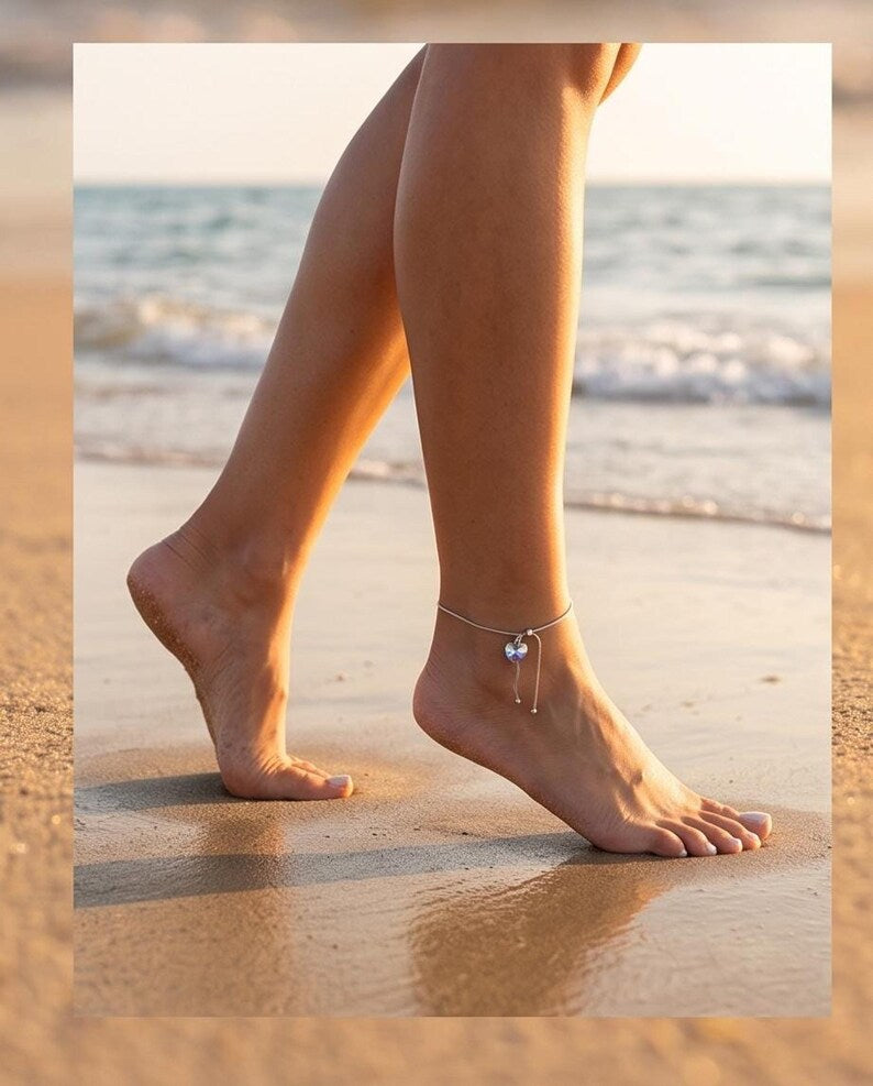 Model walking barefoot on beach wearing anklet