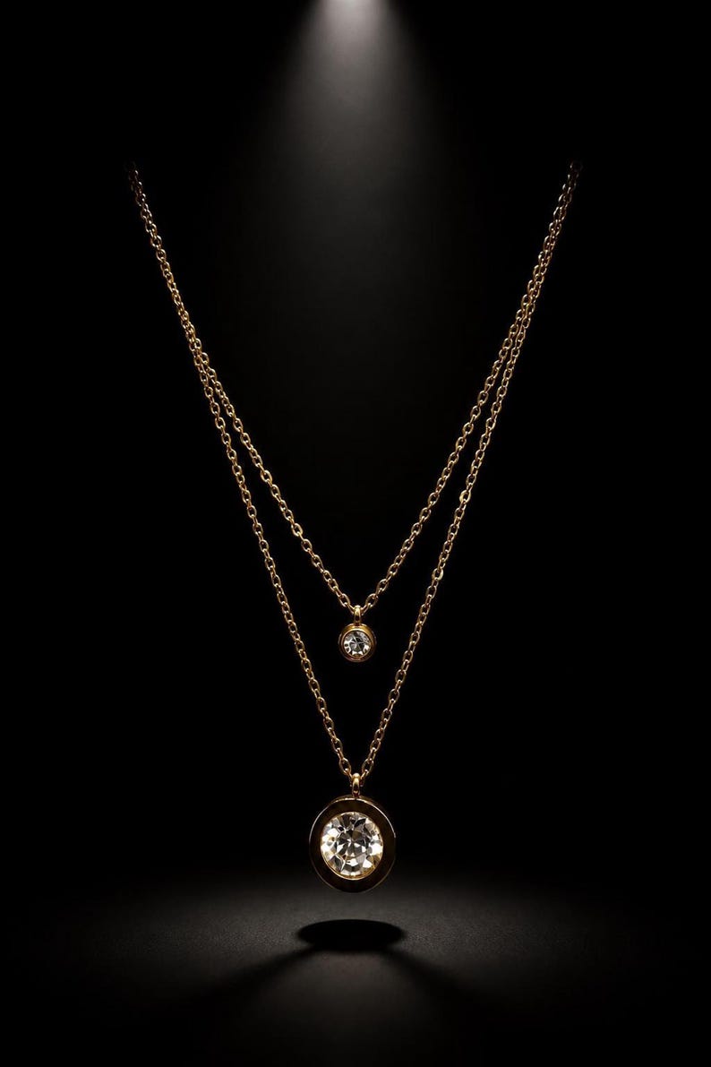 Layered gold CZ necklace on black background