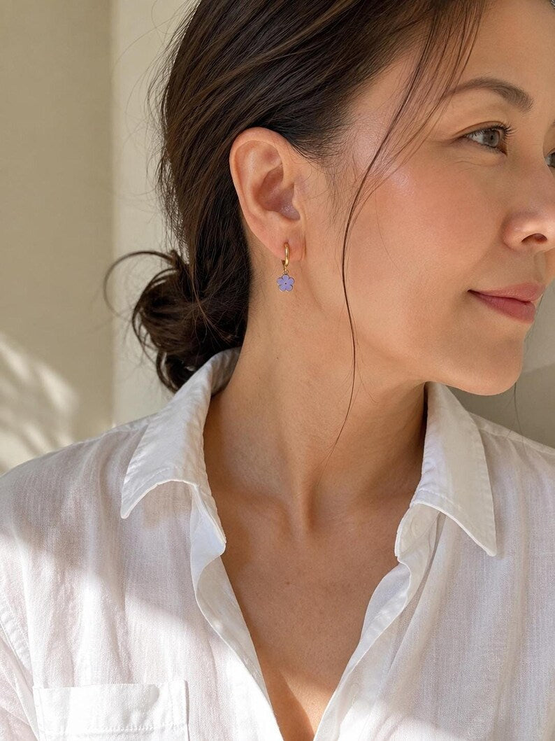 Close-up profile wearing gold flower huggie earring