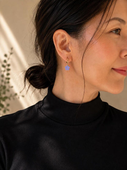 Profile shot wearing gold flower charm hoop earring
