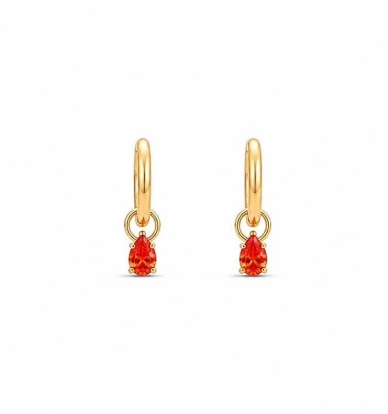 Studio shot of red garnet CZ huggie hoop earrings