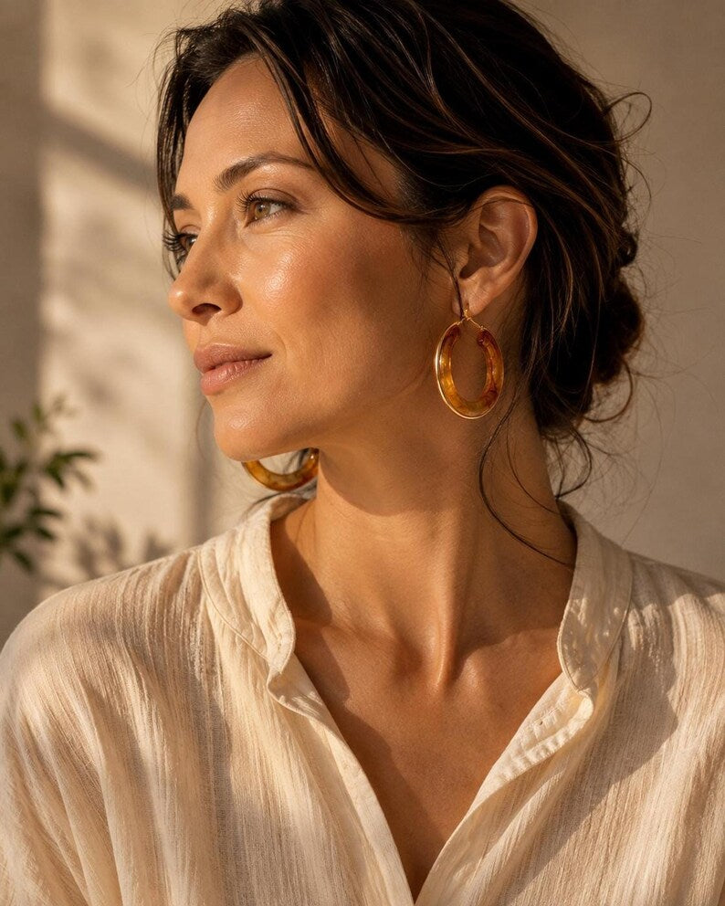 Woman wearing amber tortoiseshell hoop earrings with gold trim