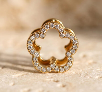 Close-up macro shot of gold flower hoop earring with pave stones