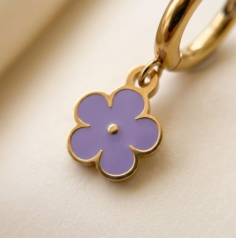 Macro shot of gold-rimmed purple enamel flower charm