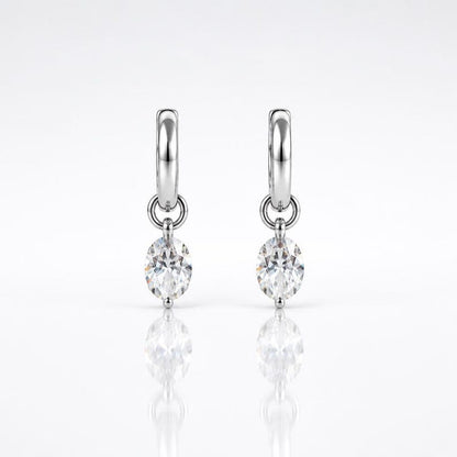 Pair of moissanite huggie hoop earrings on white background