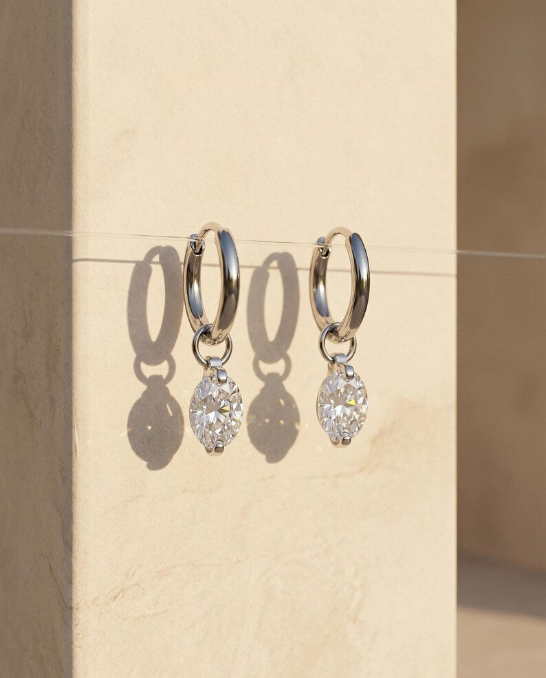 Moissanite huggie earrings hanging on wire