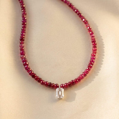 Ruby beaded necklace displayed on folded fabric