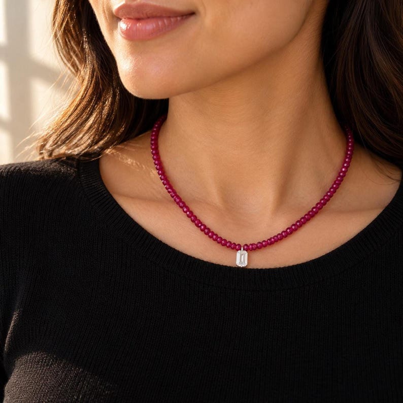 Close-up portrait wearing ruby beaded necklace over black top